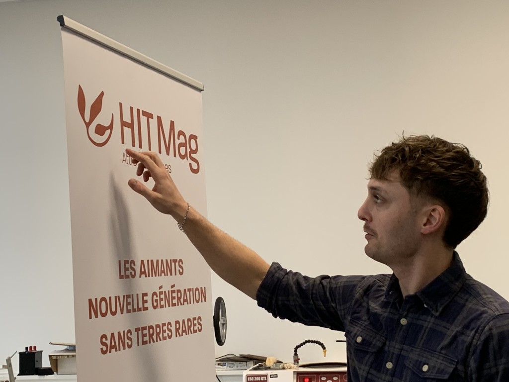 Antoine explique le logo de HIT Mag sur leur roll-up